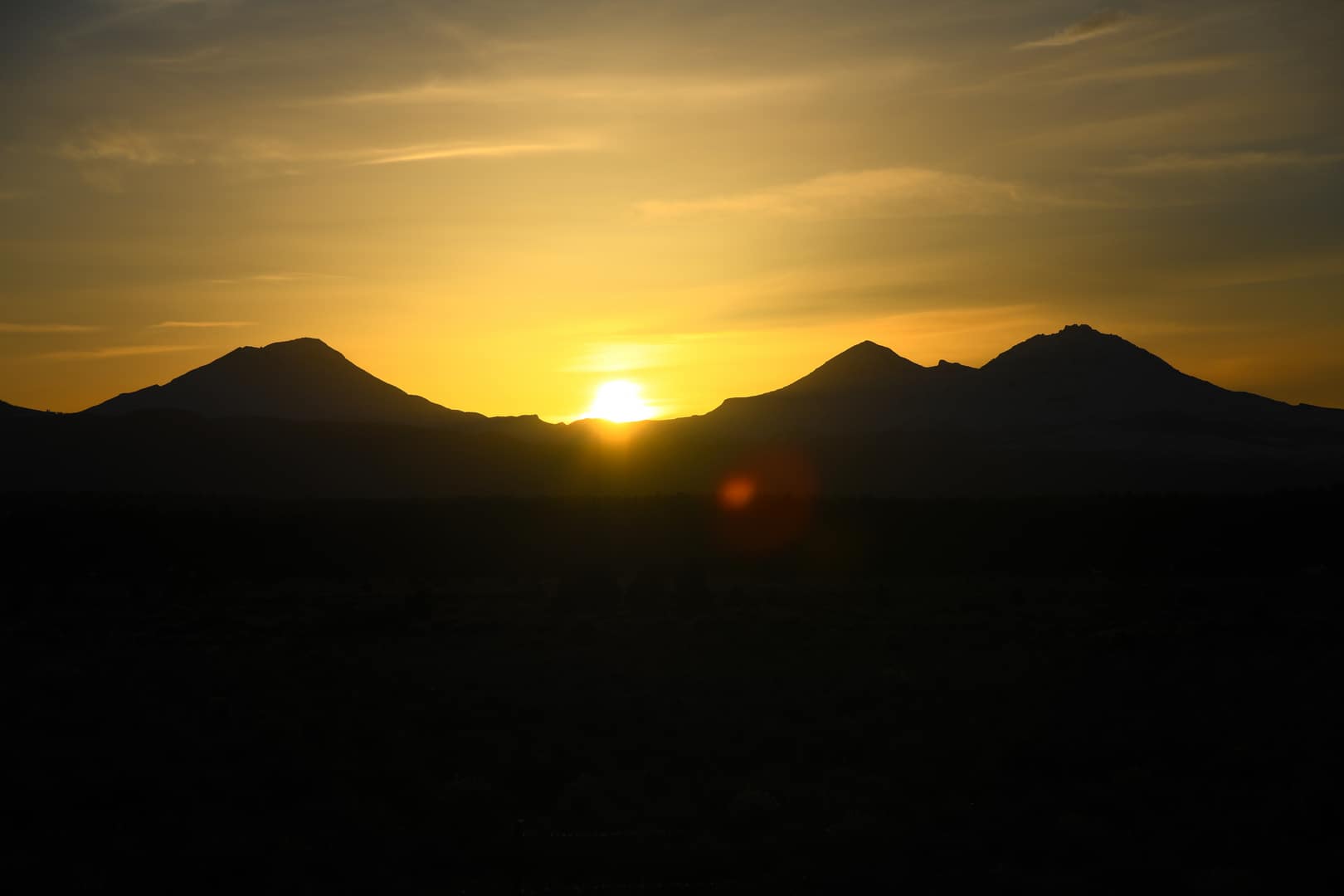 The Sun setting behind the Three Sisters near Bend, Oregon.